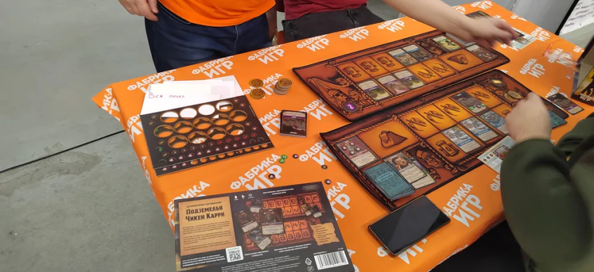 Настолка по мотивам шоу "Подземелья Чикен Карри" — типичная карточная игра в духе MtG и "Берсерк: Герои". Хотя есть и нюансы вроде карт-напарников и того, что карты-войска атакуют только клетку перед собой.