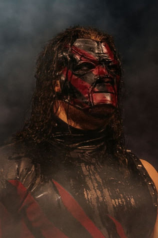 Кейн (Glenn Jacobs) дебютировал в&amp;nbsp;1997 как «Большой Красный Монстр»&amp;nbsp;— полумаска, обожжённое лицо, пиротехника и&amp;nbsp;чокер. Брат Гробовщика в&amp;nbsp;сюжетах, известен разрушительными фьюдами, поджогами гробов и&amp;nbsp;титулами (2x WWE Champion). Переходил между хилом (агрессивный демон) и&amp;nbsp;фейсом (герой-монстр).