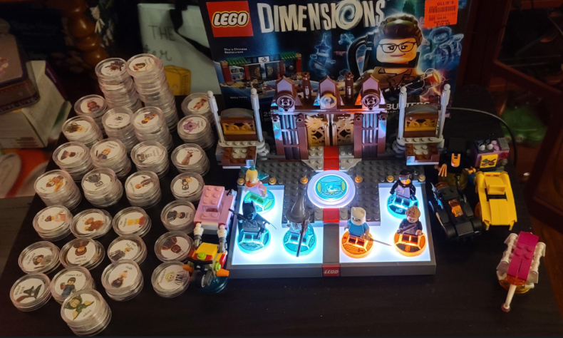 Фото не мое, но примерно так выглядел мой сетап для игры. Те самые фишки слева делаются при помощи покупки кейсов для монет и NFC наклеек, ну и распечатка изображений. Думаю не нужно объяснять, почему данный вариант намного дешевле покупки самих наборов.