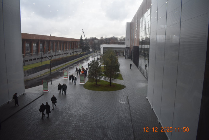 Странно
устроен комплекс: заходишь в помещение, расстёгиваешь верхнюю одежду для
проверки, получаешь бейджик и идёшь в основные залы… по улице!