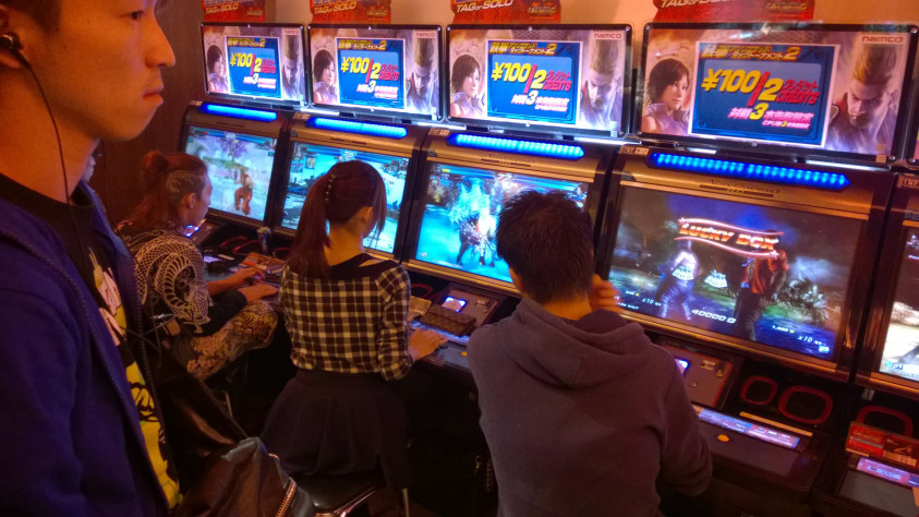 Японская аркада, на картинке люди играют в Tekken tag tornament 2. 2014 год.